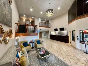 ein großes Wohnzimmer mit Sofas und einer Treppe in der Unterkunft Best Western Plus Executive Hotel & Suites in Sulphur