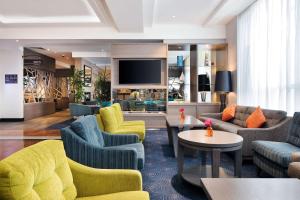 a lobby with couches and chairs and a television at Hilton Garden Inn Dublin City Centre in Dublin
