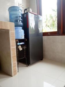 a black refrigerator sitting next to a window at Ubud nadi villa in Tegalalang