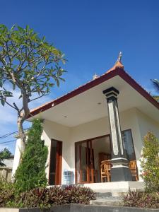 Una casa blanca con un árbol delante. en Ubud nadi villa, en Tegalalang