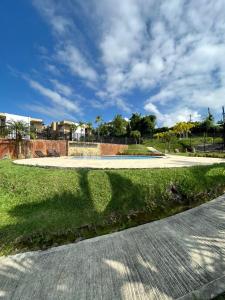 einen Gehweg in einem Park unter einem blauen Himmel in der Unterkunft Apartamento en el Eje Cafetero Quindio con piscina jacuzzi wifi in La Tebaida