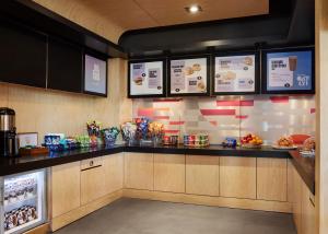 a restaurant kitchen with a counter with food and drinks at Aloft Leawood-Overland Park in Overland Park
