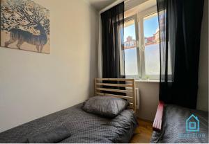a bedroom with a bed and a window at Trio Room in Gdańsk