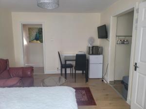 a room with a bed and a table and chairs at Lovely studio flat in Reading