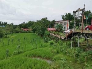 a bridge over a field with a house on it at SMyleINN Farm in San Fernando