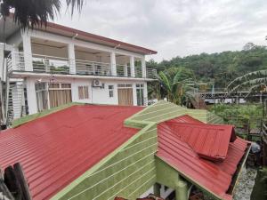 dom z czerwonym dachem na górze w obiekcie SMyleINN Farm w mieście San Fernando