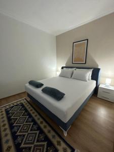 a bedroom with a large white bed and a rug at BLUE APARTMENT MOSTAR in Mostar
