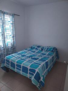 a bedroom with a bed with a blue and white comforter at RESIDENCIA EN VERACRUZ in Veracruz