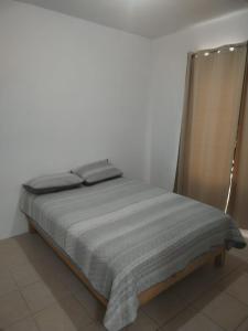 a bed in a white room with a gray blanket at RESIDENCIA EN VERACRUZ in Veracruz