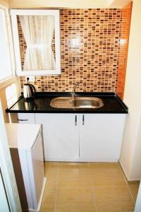 un bancone della cucina con lavandino e specchio di Mavi Butik Apart a Çeşme