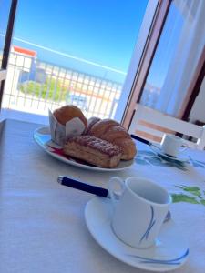 einen Teller Brot und eine Tasse Kaffee auf dem Tisch in der Unterkunft Orizzonte Mare House in Torino di Sangro