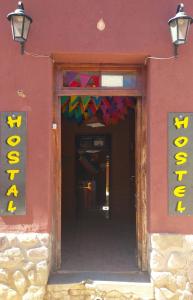 Humahuaca Hostel في هوماهواكا: مبنى احمر مكتوب عليه خروج