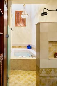 a bath tub in a bathroom with a chandelier at Casa Lecanda Boutique Hotel in Mérida