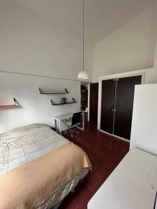Un dormitorio con una cama, un escritorio y una silla. en Apartamento sobre Gorlero, en Punta del Este