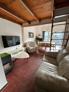 sala de estar con sofá y TV en Apartamento sobre Gorlero, en Punta del Este