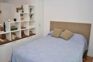 Schlafzimmer mit einem blauen Bett und weißen Regalen in der Unterkunft Chacabuco 255 by depptö in San Isidro