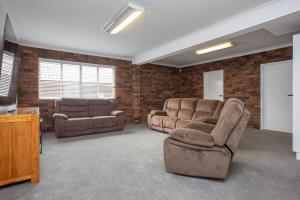 ein Wohnzimmer mit 2 Sofas und einem TV in der Unterkunft Hillvue Lodge in Tamworth