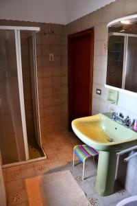 bagno con lavandino giallo e doccia di Casa Antica Canosa a Canosa di Puglia
