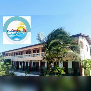 a building with a palm tree in front of it at Pousada Embarcacao in Tutóia