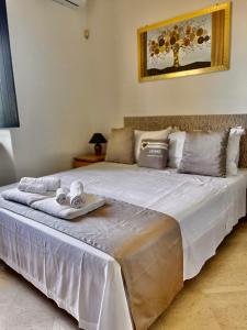 a large white bed with a tray of towels on it at Villa Pignatelli in Bari