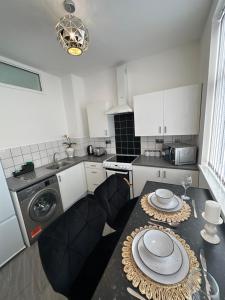 cocina con mesa y lavadora en Lovely 2 Bedroom Apartments In Manchester Close To City Centre And Manchester City Stadium #1 en Mánchester