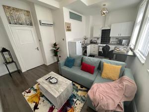 sala de estar con sofá azul y cocina en Lovely 2 Bedroom Apartments In Manchester Close To City Centre And Manchester City Stadium #1 en Mánchester