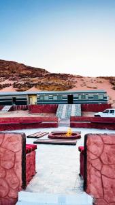 a building with a fire pit in the middle at Miral Night Camp in Wadi Rum