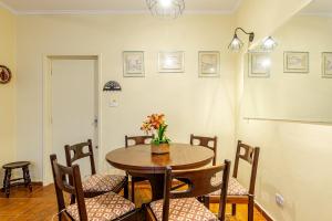 Un comedor con mesa y sillas en Apê Clássico e Aconchegante no Guarujá - 350 m da praia, en Guarujá