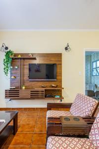 Una sala de estar con un televisor en la pared. en Apê Clássico e Aconchegante no Guarujá - 350 m da praia, en Guarujá