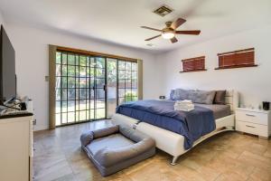 a bedroom with a bed and a couch and windows at Lake Balboa Home with Scenic Patio Near Van Nuys! in Van Nuys