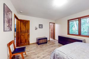 a bedroom with a bed and a chair and a window at Raspberry Retreat in Anchorage