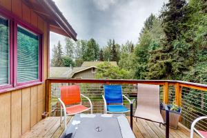 una terraza con 4 sillas y una mesa. en Raspberry Retreat en Anchorage