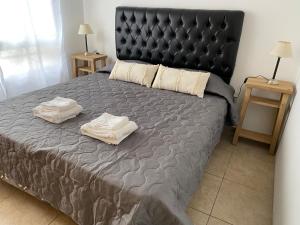 ein Schlafzimmer mit einem großen Bett mit zwei Handtüchern darauf in der Unterkunft Castelli 630 in La Plata
