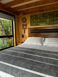 a bedroom with a large bed and a window at Aysén Lodge - Cabaña con Tinaja in Puerto Dunn