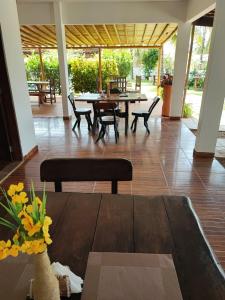 a dining room with a wooden table and chairs at Pousada Sunshine Patacho - Praia do Patacho - Rota Ecológica dos Milagres, Porto de Pedras in Pôrto de Pedras