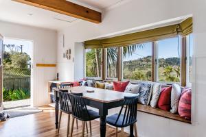 a living room with a couch and a table and chairs at Karioi View in Raglan