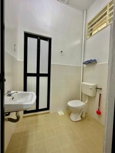 uma casa de banho com um WC branco e um lavatório. em Shaleishah Homestey em Kuantan