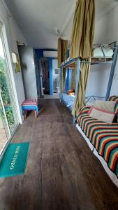 a room with two bunk beds and a wooden floor at Hostel Tribos Livres in Torres