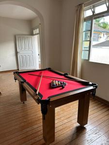 a pool table in a room with a red cloth at Casa no Centro de Serra Negra in Serra Negra