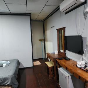Kampong JuaraにあるPermai Chalet Tiomanのデスク(テレビ付)、テーブル(デスク付)が備わる客室です。