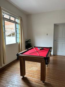 a room with a pool table in a room with a window at Casa no Centro de Serra Negra in Serra Negra