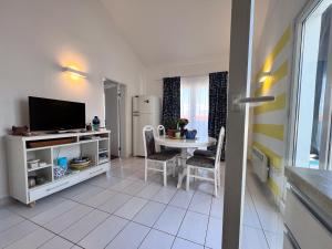 a living room with a table and a television at Attico "NIDO" a 50m dal mare con terrazzo grande - un'oasi di pace e bellezza in Nečujam