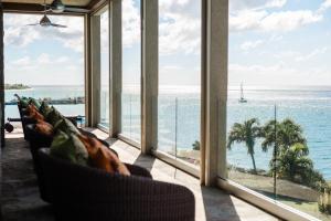 a living room with windows looking out at the ocean at Beautiful 3 story 8,000 sq ft Oceanside Mansion in Nevis