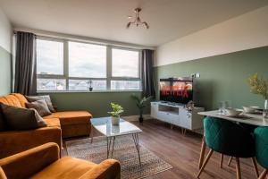 a living room with a couch and a tv at Central Maidstone Contractor Flat, Sleeps 6 - FREE Parking in Maidstone