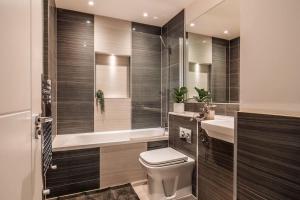 a bathroom with a toilet and a sink and a tub at Central Maidstone Contractor Flat, Sleeps 6 - FREE Parking in Maidstone