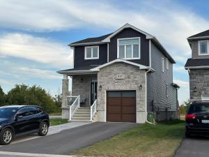 una casa negra con un coche aparcado delante de ella en Luxury Detached House Kingston en Kingston