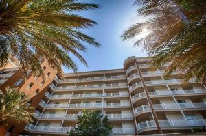 a tall building with palm trees in front of it at Reflections by Panhandle Getaways in Panama City Beach