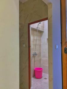 a bathroom with a shower with a pink bucket at Casa Ali in Chefchaouen