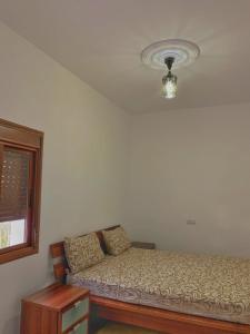 Casa Ali في شفشاون: غرفة نوم صغيرة بها سرير ونافذة