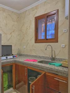 a kitchen with a sink and a window at Casa Ali in Chefchaouen